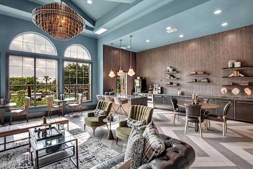 Open lounge and bar area with tall windows, mixed seating, and modern finishes.