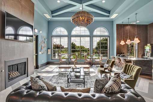 Resident lounge with arched windows, chandelier lighting, and seating near a bar.