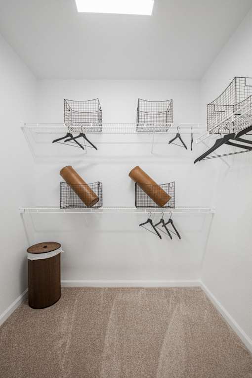 Spacious walk-in closet with wire shelving, hanging rods, and overhead lighting.