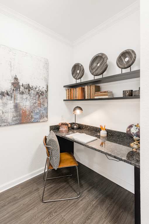 Built-in desk nook with granite work surface, floating shelves, and task lighting.