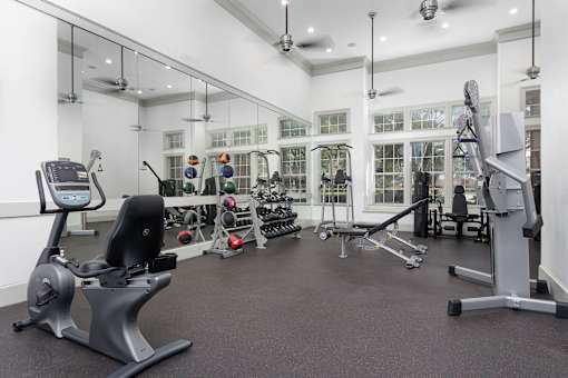 A gym with a variety of equipment including treadmills, weights, and exercise machines.