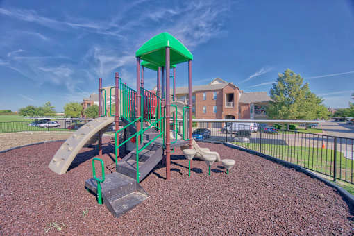 A playground with a green roof and a slide.