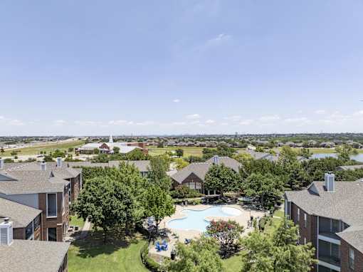 A large apartment complex with a pool and a view of the water.