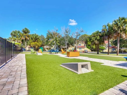 a park with a grassy area and a black fence