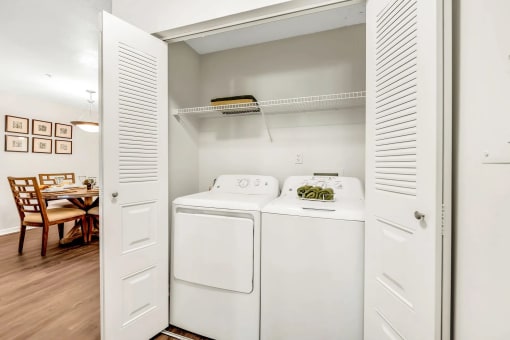 a washer and dryer in a room with a dining table in the background