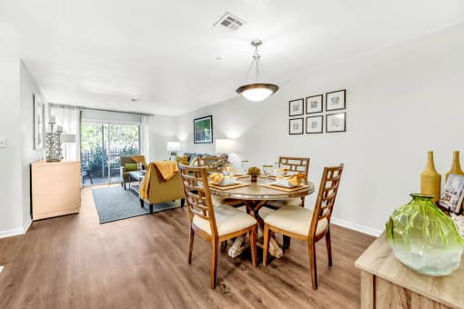 a dining room with a table and chairs and a living room in the background