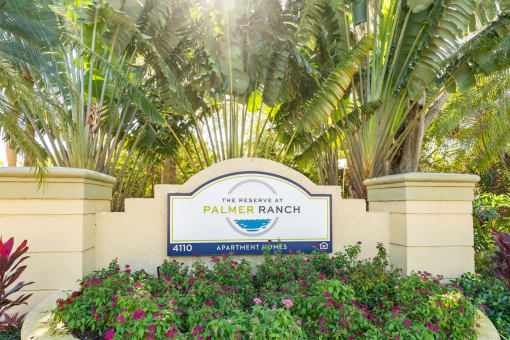 a sign that says palmer ranch with palm trees in the background