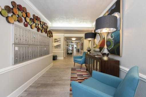 a hallway with blue couches and chairs and a large painting on the wall