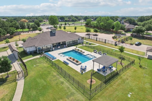 an aerial view of a swimming pool in front of a house