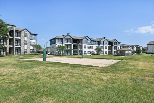 an open field with an apartment building in the background