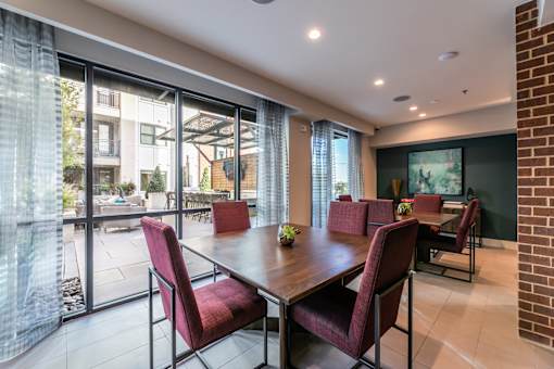 A seating area with a table and chairs facing a swimming pool.