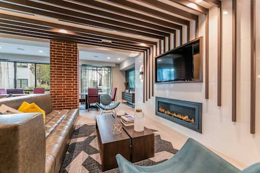 A modern clubroom with a fireplace and a television.