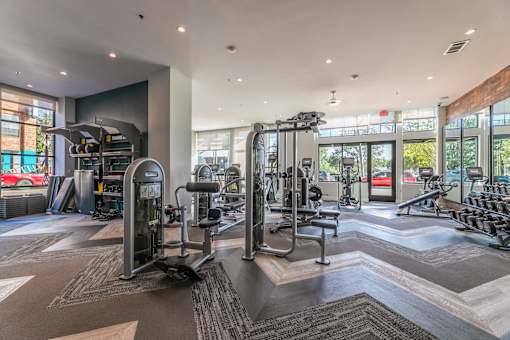 A fitness center with a variety of equipment including treadmills, weights, and exercise machines.