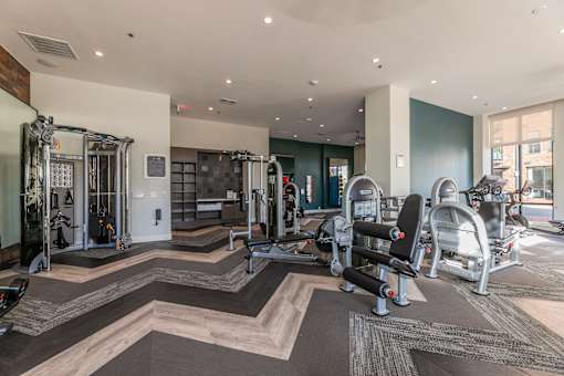 A fitness center with a variety of equipment including treadmills, weights, and exercise machines.