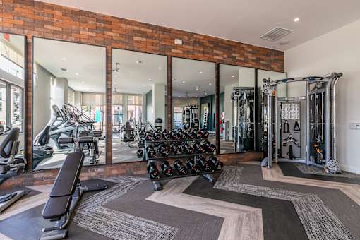 A fitness center with a variety of equipment including weights and cardio machines.