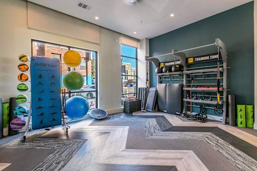 A fitness center with a variety of equipment including an exercise ball and exercise mats.