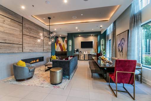 A modern clubroom with a fireplace and a dining area.