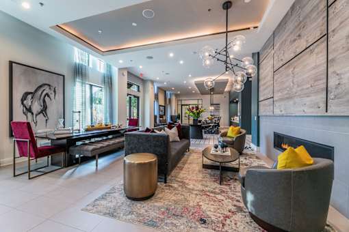 A modern clubroom with a grey sofa and a fireplace.