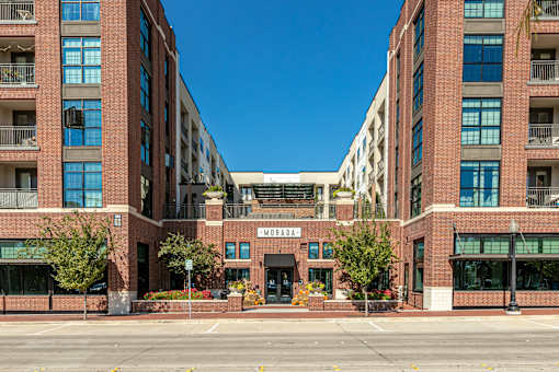 Exterior of a large brick wrap-style apartment building.