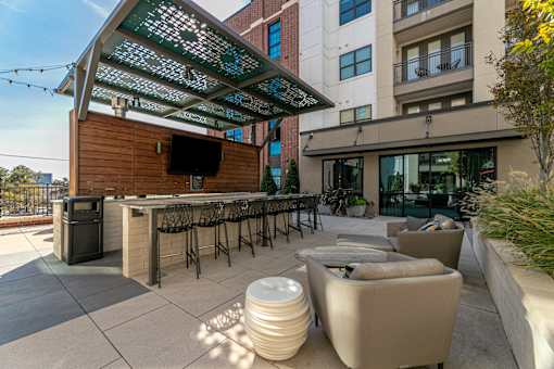 A patio with a bar and seating area.