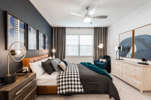 a bedroom with a bed and a dresser in front of a window