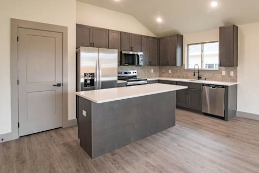 A kitchen with a white countertop and stainless steel appliances.