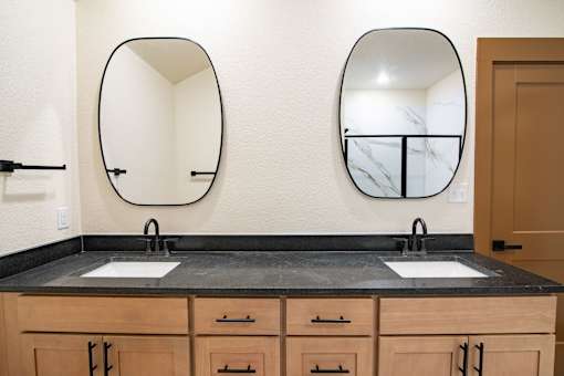 A bathroom with two sinks and two mirrors.