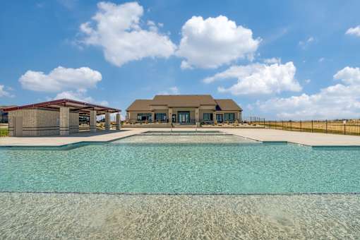 A large swimming pool in front of a house.