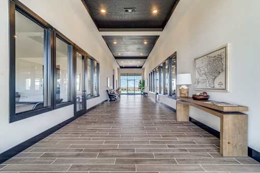 A long hallway with a bench and a map on the wall.