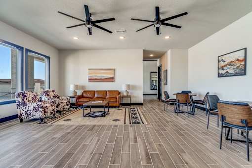 A living room with a wooden floor and ceiling fans.