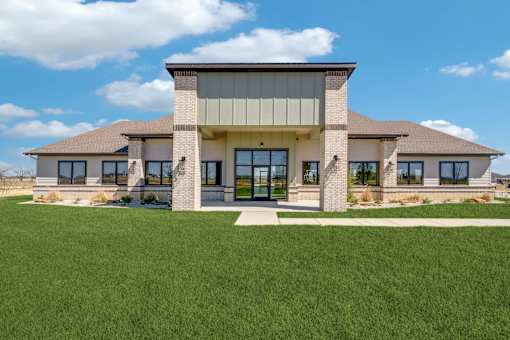 A modern house with a large front yard.
