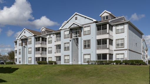an apartment building on a hill with a grassy area in front of it