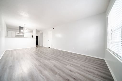 an empty living room with white walls and wood floors