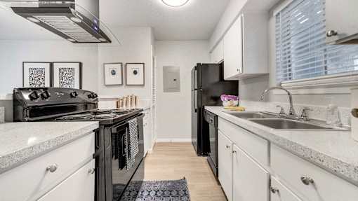 a kitchen with white cabinets and black appliances