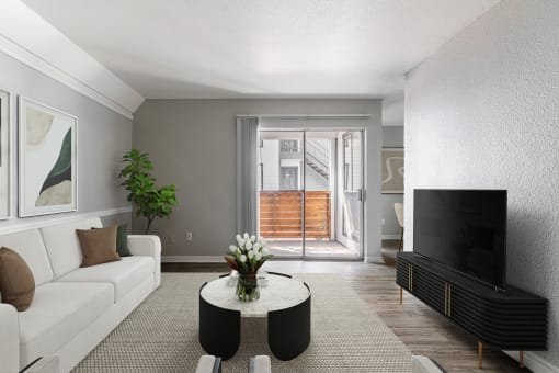 a living room with a white couch and a coffee table and a television