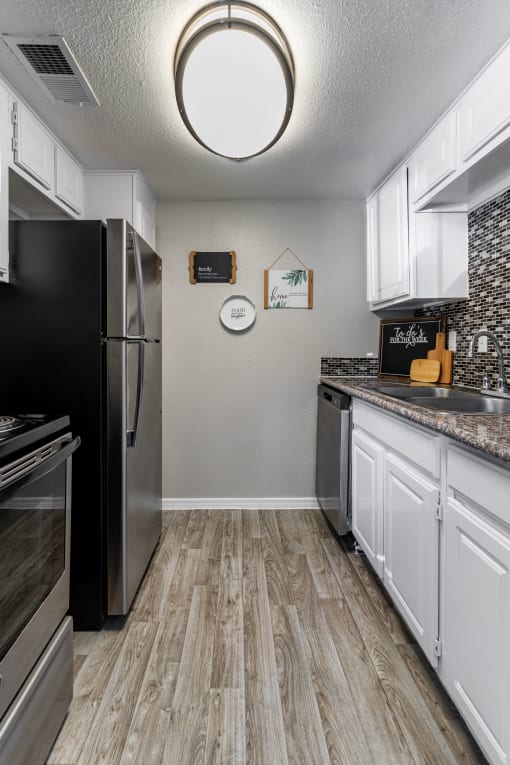 a kitchen with stainless steel appliances and white cabinets