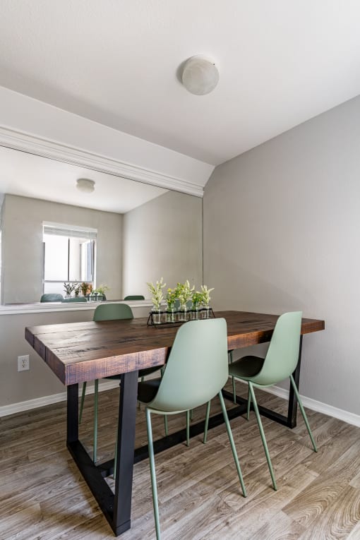 a dining room with a wooden table and green chairs
