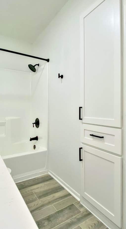 A white bathroom with a tub and a cabinet.