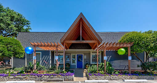 A house with a blue door and a wooden roof with a pergola.