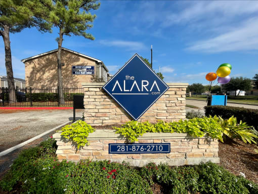 a sign that says the alara condominiums with a building in the background  at The Alara, Houston, 77060