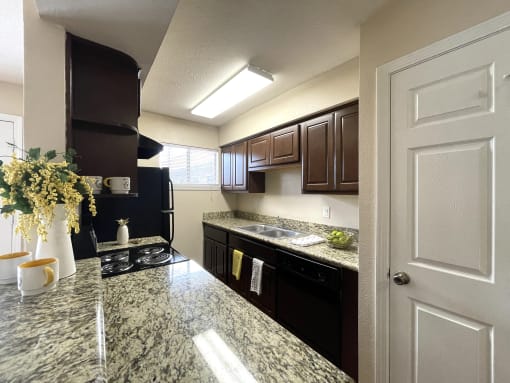 a kitchen with black appliances and granite counter tops