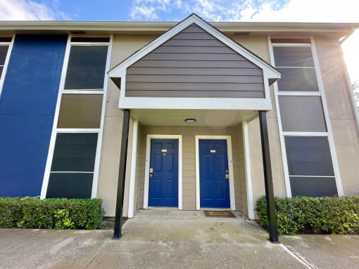 a building with two blue doors and a porch