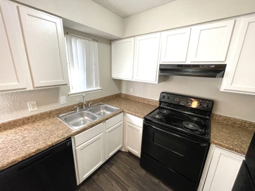 a kitchen with black appliances and white cabinets
