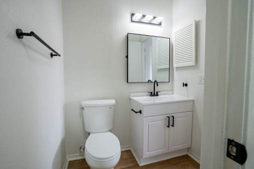 A white toilet sits next to a sink in a half-bath.