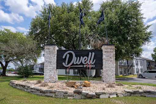 A sign for Dwell is in front of a building.
