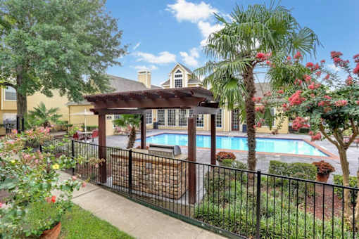 A pool area with a black fence and a gazebo.