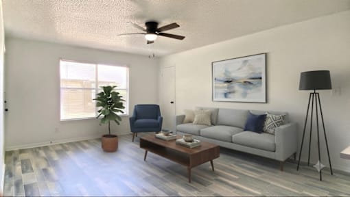 A living room with a blue chair and a grey couch.