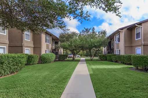 A long concrete walkway separates two rows of apartment buildings.