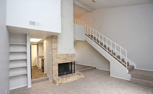 a living room with a fireplace and a staircase  at 1505 Exchange Apartments, Texas, 76112