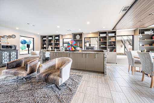 A modern living room with a grey rug and two chairs.